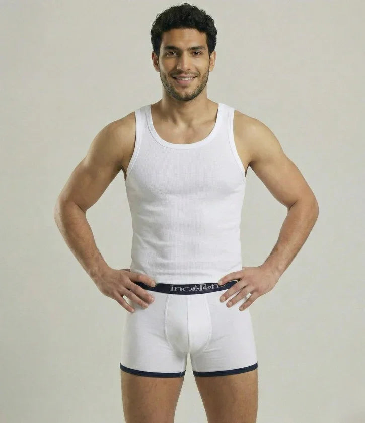 Man wearing a white tank top and underwear set on a plain background