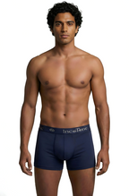 Man wearing navy blue boxer briefs with a visible brand logo on a white background