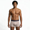 Man wearing beige underwear with a visible brand logo on a white background